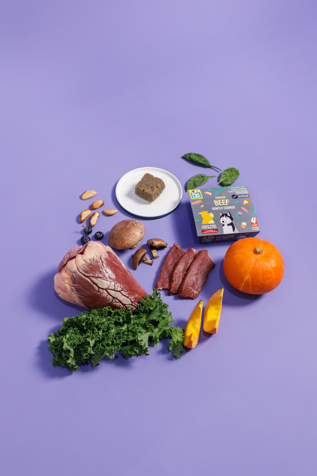 raw meat, vegetables, and a package on a purple background
