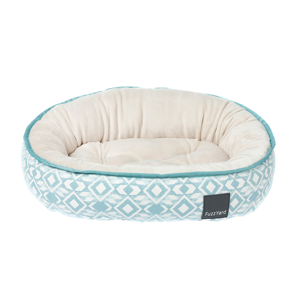 fuzzyard reversible pet bed chaouen - waku waku pets. 
A round pet bed with a plush cream-colored interior and a pastel light blue and white geometric patterned exterior.
