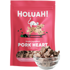 A pink stand-up pouch of HOLUAH! Single-Ingredient Pork Heart dog treats, shown with a small clear glass bowl filled with the brown cube-shaped treats in front. The package features a cartoon illustration of a cat and dog on a skateboard.